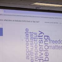 word cloud projected on a projector screen, words "appreciate, enthusiast, respectful, diversity, belong, freedom, matter